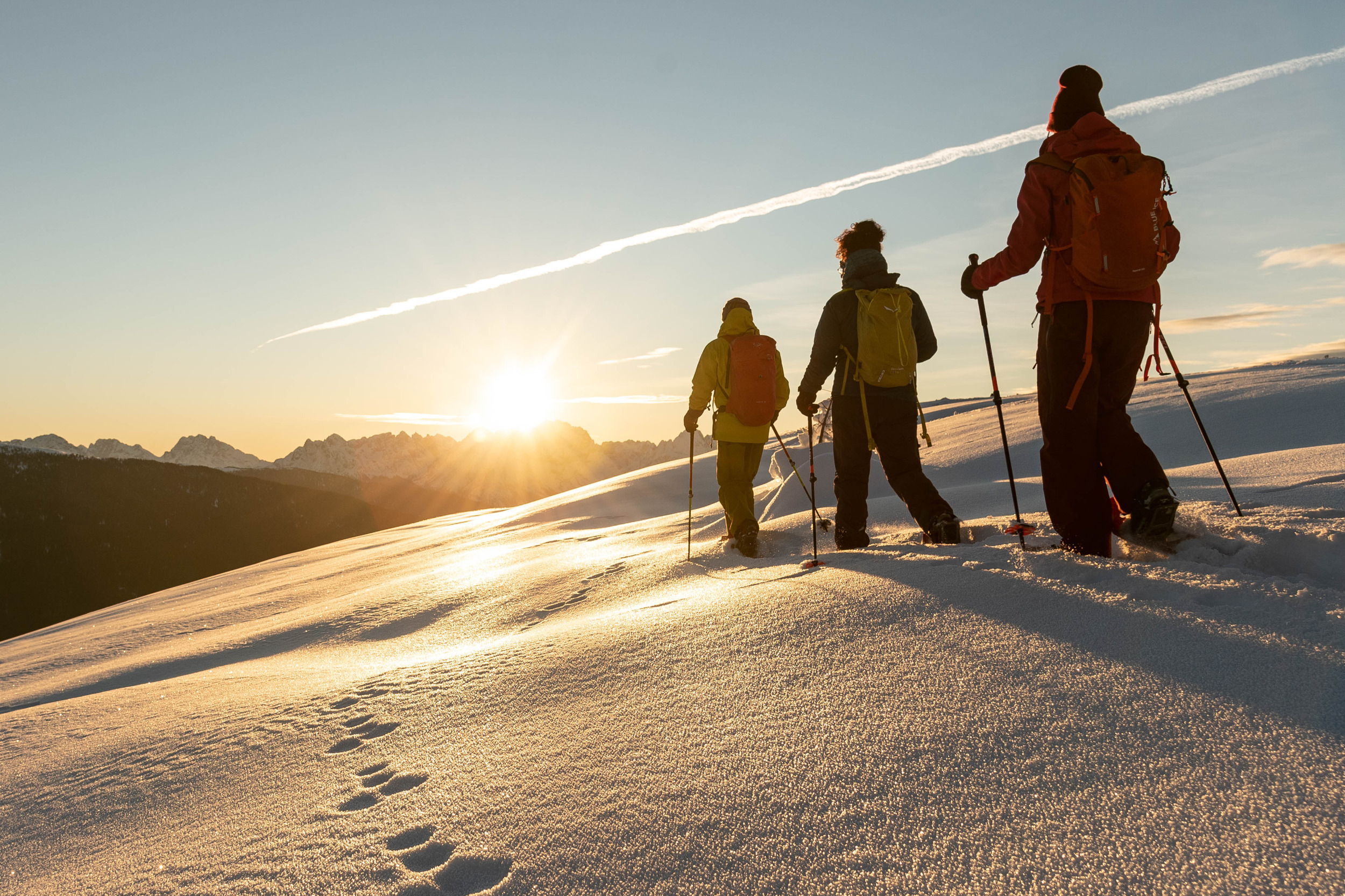 Schneeschuwanderung bei Sonnenaufgang auf verschneite Almen